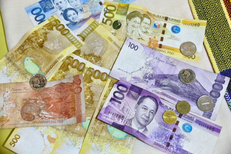 Philippine peso banknotes and coins laid out on a table
