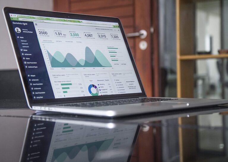 Laptop screen showing charts and statistics on a glossy desk — competitor and product research workspace