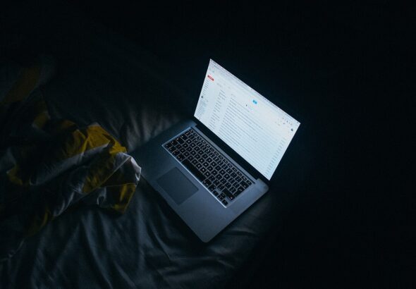 Person reading email on a laptop screen at night — welcome and nurture email sequence workspace