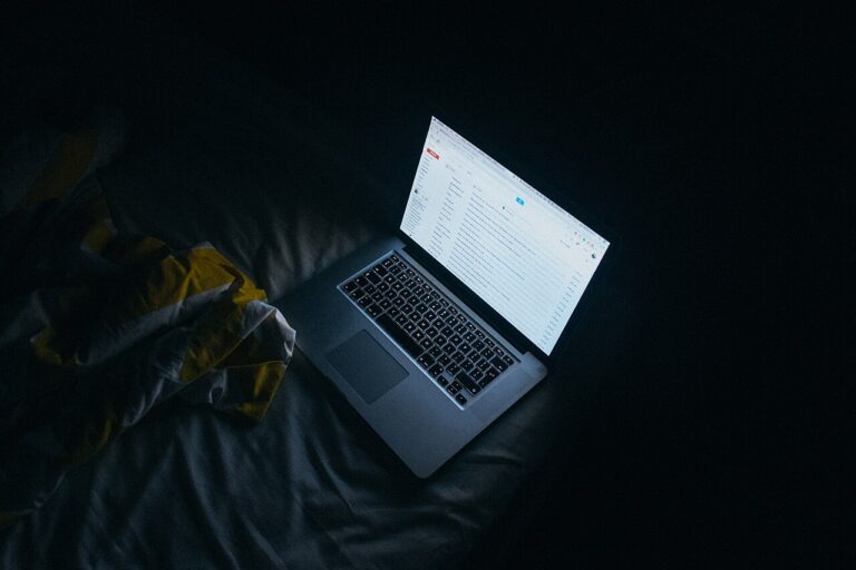 Person reading email on a laptop screen at night — welcome and nurture email sequence workspace