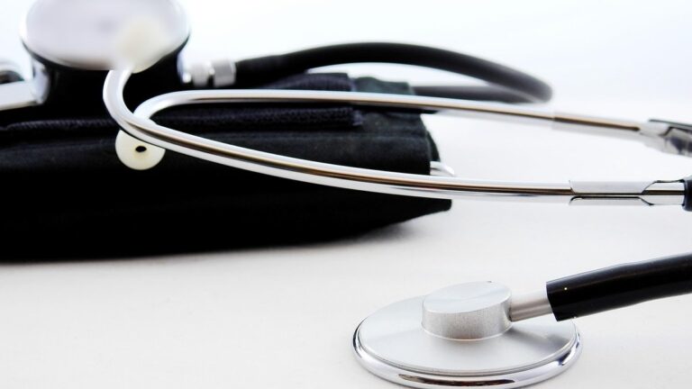 Stethoscope and blood pressure cuff on a white desk