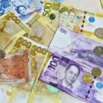 Philippine peso banknotes and coins laid out on a table