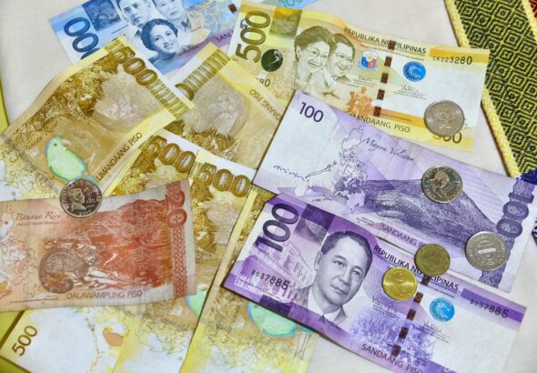 Philippine peso banknotes and coins laid out on a table