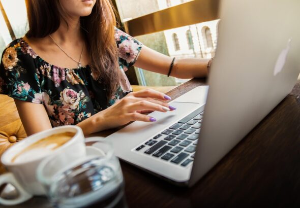 Freelancer working on a laptop at a desk with a cup of coffee