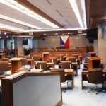 Empty Philippine Senate Session Hall with the Philippine flag behind the rostrum