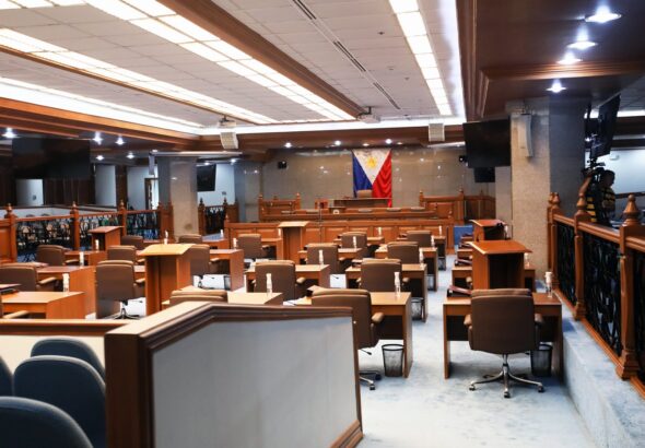 Empty Philippine Senate Session Hall with the Philippine flag behind the rostrum