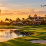 Palm-lined Florida golf course and clubhouse at sunset with a jet overhead